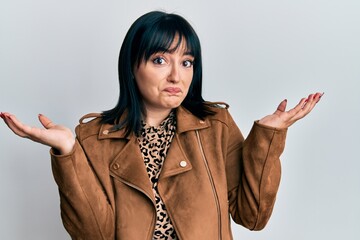 Sticker - Young hispanic woman wearing casual leather jacket clueless and confused with open arms, no idea and doubtful face.