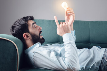 surprised man holding light bulb