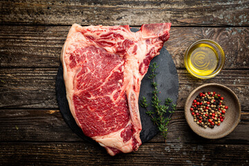 Wall Mural - Raw fresh meat T-bone beef Steak on wooden background, top view