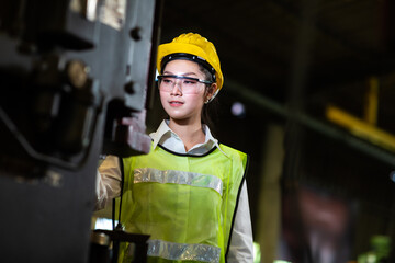 Wall Mural - Woman worker wearing safety goggles control lathe machine to drill components. Metal lathe industrial manufacturing factory