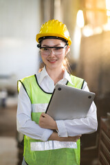 Woman worker wearing safety goggles control lathe machine to drill components. Metal lathe industrial manufacturing factory