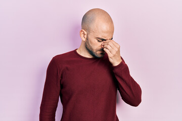 Young bald man wearing casual clothes tired rubbing nose and eyes feeling fatigue and headache. stress and frustration concept.