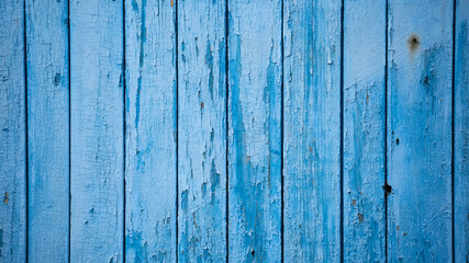 aged blue planks with peeled paint. blue background. close-up. copy space. defocus.