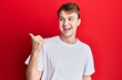 © Krakenimages.com - Young caucasian man wearing casual white t shirt pointing thumb up to the side smiling happy with open mouth