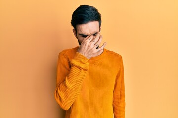 Wall Mural - Young hispanic man wearing casual clothes tired rubbing nose and eyes feeling fatigue and headache. stress and frustration concept.