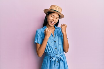 Sticker - Young chinese woman wearing summer hat celebrating surprised and amazed for success with arms raised and eyes closed