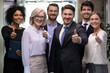 © fizkes - Portrait of smiling multiethnic team show thumbs up give recommendation to good quality service. Happy diverse multiracial businesspeople recommend company or bank experience. Employment concept.