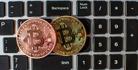 Two bitcoin placed on a laptop computer keyboard in the daytime. concept digital currency, Close-up, blurred background