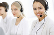 © Iryna - Call center. Group of diverse operators at work. Beautiful woman in headset communicating with customers of telemarketing service. Business concept