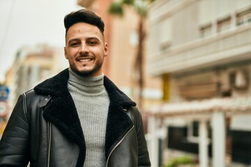 Young arab man smiling happy standing at the city.