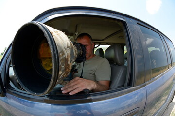 Wall Mural - wildlife photographer sitting in the car