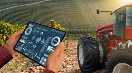Autocollant - A farmer remotely controls an autonomous tractor in a vineyard. Harvest.