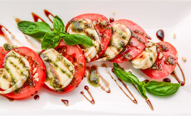 Sticker - Caprese salad with mozzarella, tomato, basil and balsamic vinegar arranged on white plate