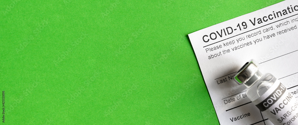 COVID-19 Vaccination Record Card on green background - obrazy, fototapety, plakaty 