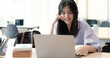 © wichayada - Young woman having online training, using laptop and wireless headset