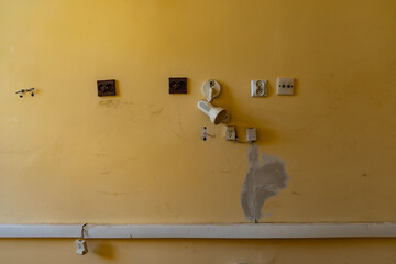 Electrical sockes on wall at urban exploration of buildings of old prison custody