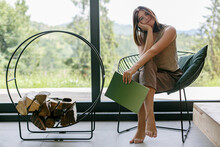 Beautiful Stylish Woman Relaxing With Book In Modern Chalet With View On Mountains. Leisure Time