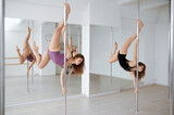 Two slim women on pole dancing training