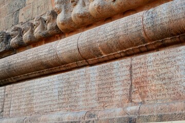 Wall Mural - Inscriptions of Tamil language carved on the stone walls at Brihadeeswarar temple in Thanjavur, Tamilnadu, India. Ancient tamil inscriptions carved in the exterior temple walls in Thanjavur.