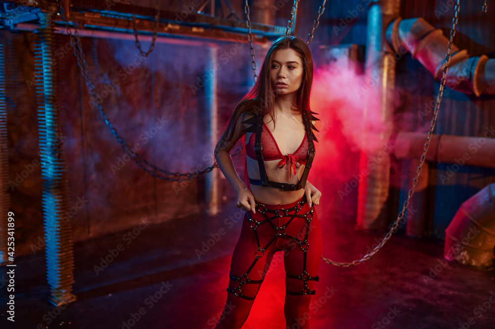 Sexy woman in red bdsm suit chained up - obrazy, fototapety, plakaty 
