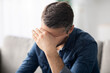 © Prostock-studio - Upset man having headache, touching his forehead