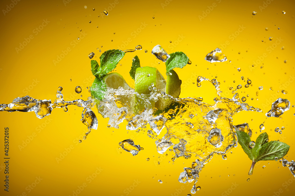 Fresh lime, mint, and ice in a splash. - obrazy, fototapety, plakaty 