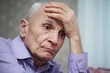 © Bonsales - Sorrowful elderly hoary man holds head with hand side close view.