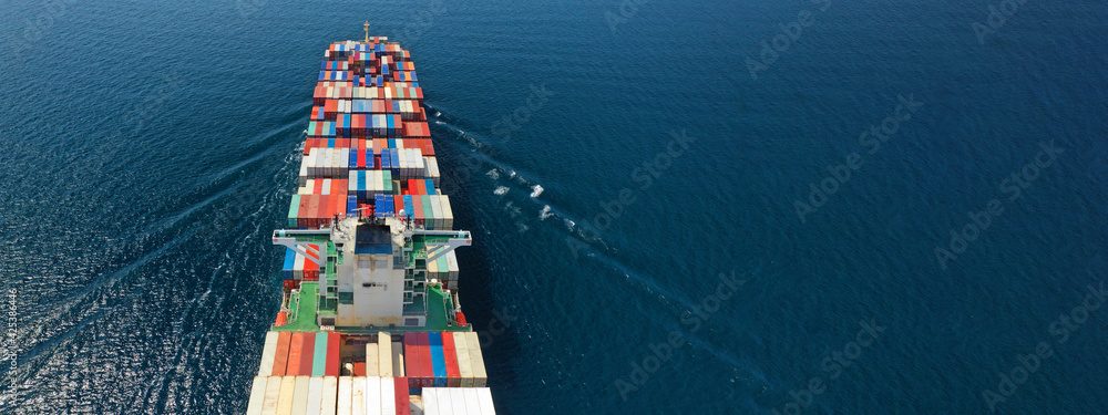 Aerial drone ultra wide photo of huge container ship cruising deep blue open ocean sea near logistics container terminal port - obrazy, fototapety, plakaty 