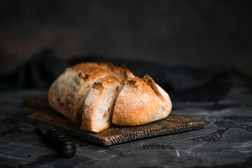 Fresh homemade sourdough bread on a dark background with copy space.