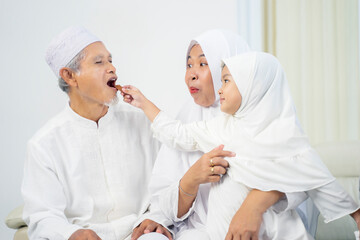 Wall Mural - Muslim little girl feeding cookies her grandparents