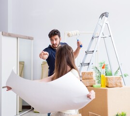 Young family unpacking at new house with boxes