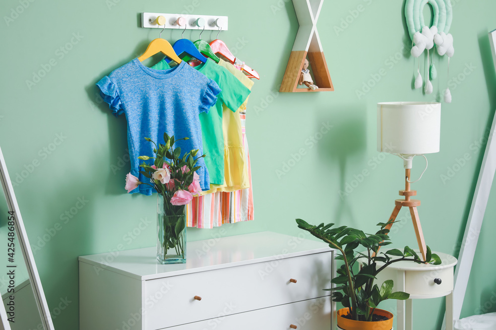 Rack with clothes in interior of children's room - obrazy, fototapety, plakaty 