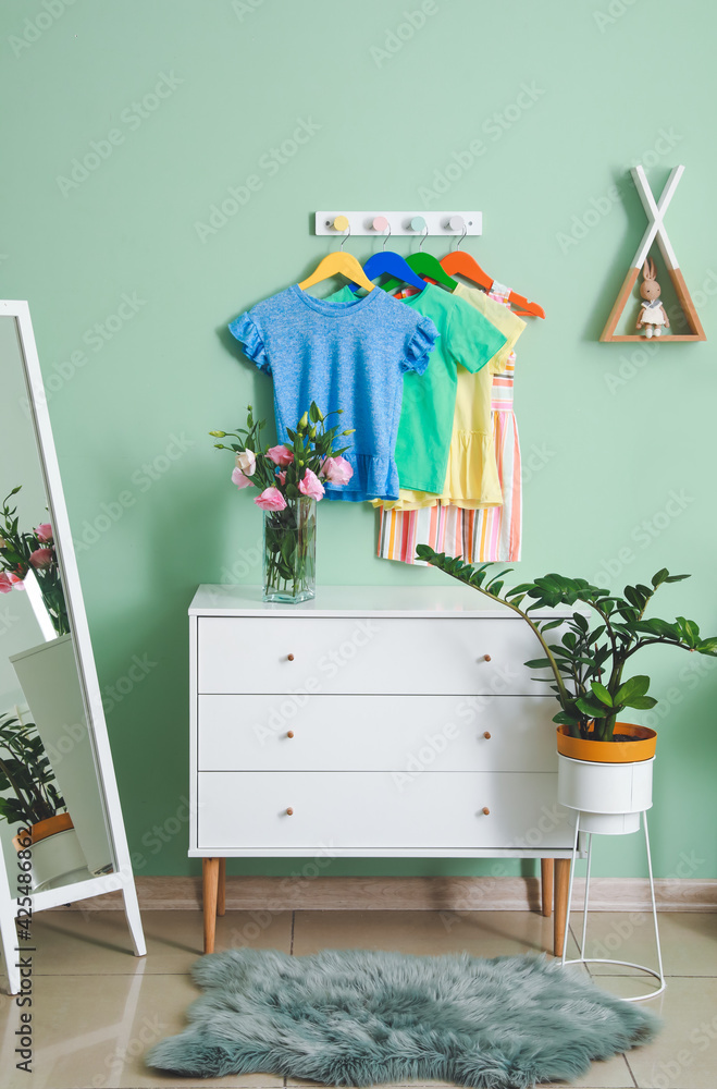 Rack with clothes in interior of children's room