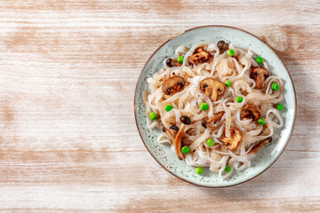 Wall Mural - Konjac pasta with mushrooms and green peas, shot from the top