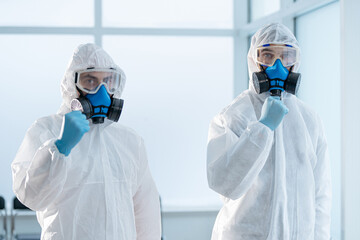 colleagues in biohazard suits standing in the lab.