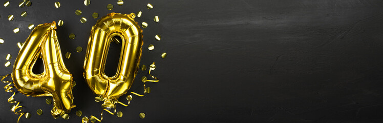 golden foil balloon number forty. Birthday or anniversary card with the inscription 40. Black concrete background. Anniversary celebration. Banner.