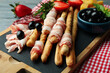 © Atlas - Board with grissini and snacks on wooden background