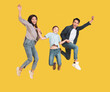 Happy young family with one child jumping together