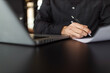 © bnenin - Close-up image of a man signing a contract.