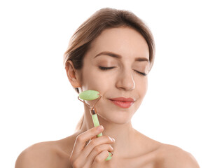 Poster - Young woman using natural jade face roller on white background