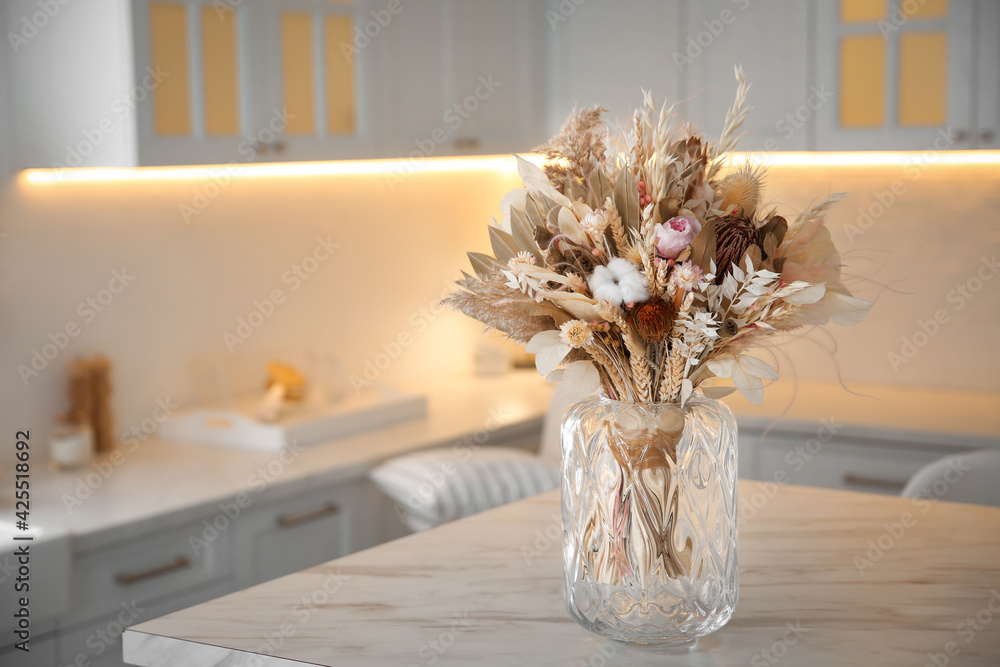 Bouquet of dry flowers and leaves on table in kitchen. Space for text - obrazy, fototapety, plakaty 