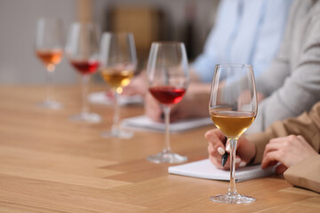 Poster - Sommeliers making notes during wine tasting at table indoors, closeup