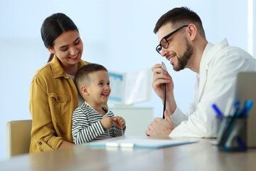 Wall Mural - Mother and son visiting pediatrician in hospital. Doctor playing with little boy