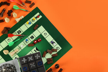 Wall Mural - Different types of board games and its' components on orange background, flat lay. Space for text