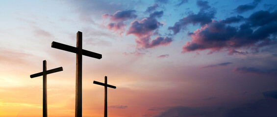 Wall Mural - Easter concept. Cross of Jesus Christ empty over dramatic sunrise sky panorama with sclouds.