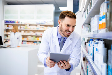 Wall Mural - Pharmacist checking medics inventory on tablet computer in drug store.