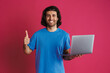 © Drobot Dean - Unshaven smiling man showing thumb up and holding laptop