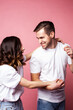 © iordani - young cheerful caucasian couple together having fun on pink background, guy ang girl modern relationship, lifestyle people concept