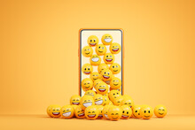 Happy emoji smile falling from smartphone screen over yellow background. Social network concept.