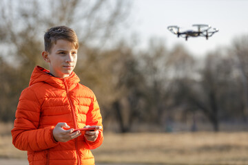 Teenage boy flying small drone in the park